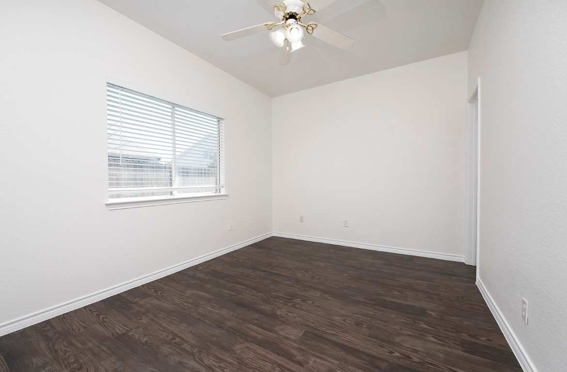 322 Tamara Drive, Unit A Georgetown, TX 78628 - Photo 12 of 17 an empty room with wooden floor chandelier fan and windows