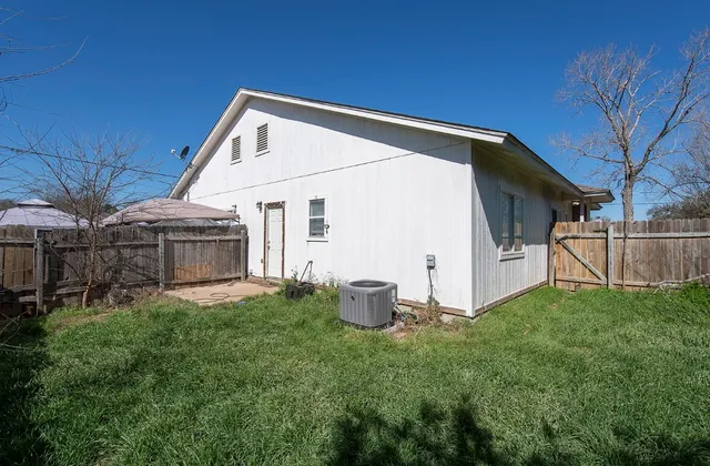 a backyard of a house with table and chairs