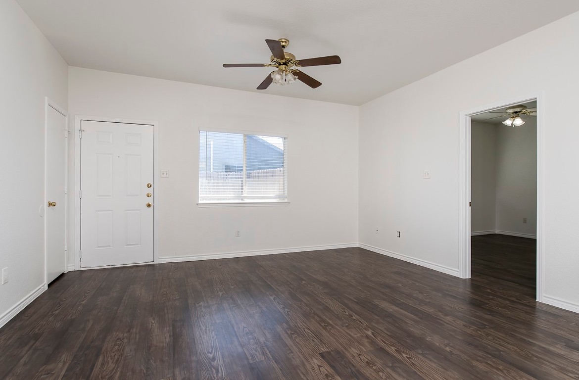 322 Tamara Drive, Unit A Georgetown, TX 78628 - Photo 5 of 17 an empty room with wooden floor chandelier fan and windows
