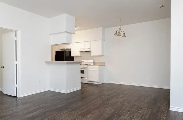 a view of a kitchen with wooden floor and a sink