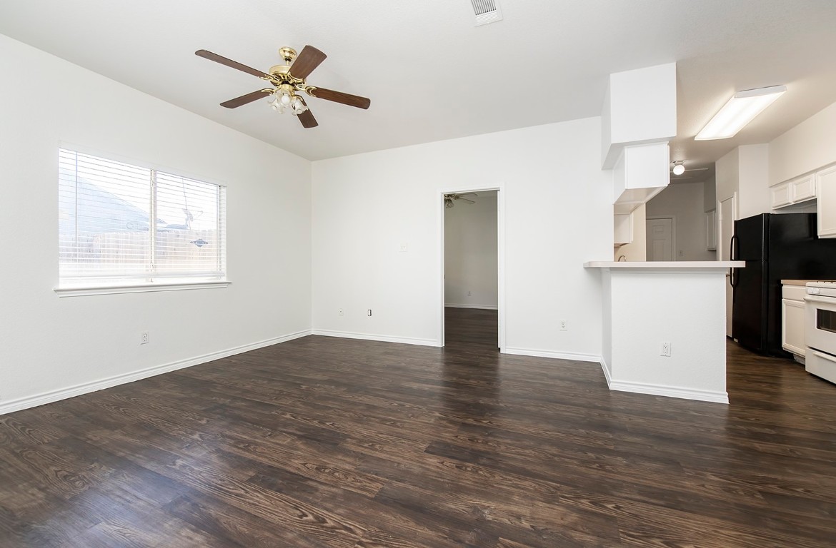 322 Tamara Drive, Unit A Georgetown, TX 78628 - Photo 7 of 17 an empty room with wooden floor and a ceiling fan