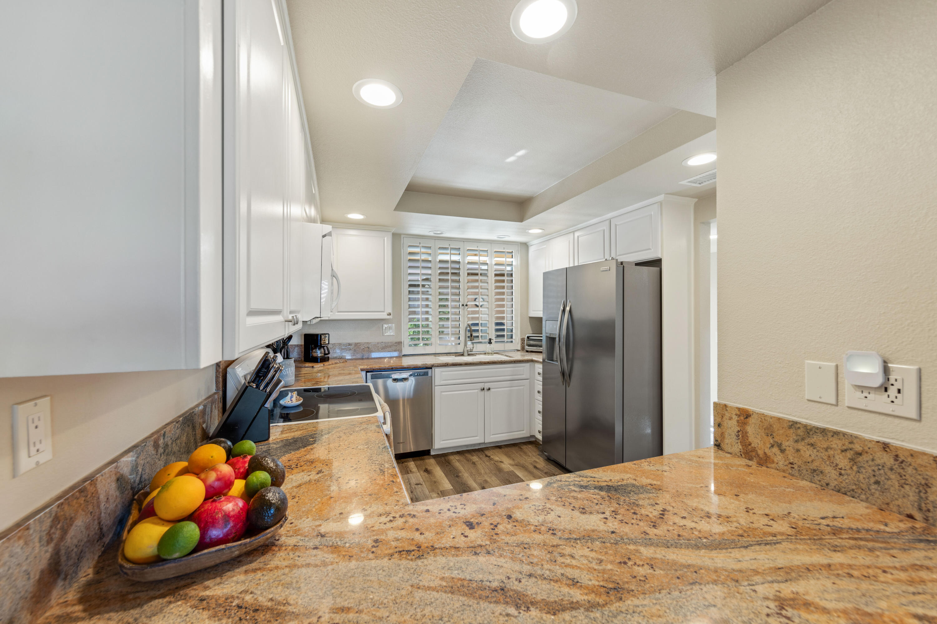 10 La Cerra Circle Rancho Mirage, CA 92270 - Photo 11 of 30 a large white kitchen with a refrigerator table and chairs