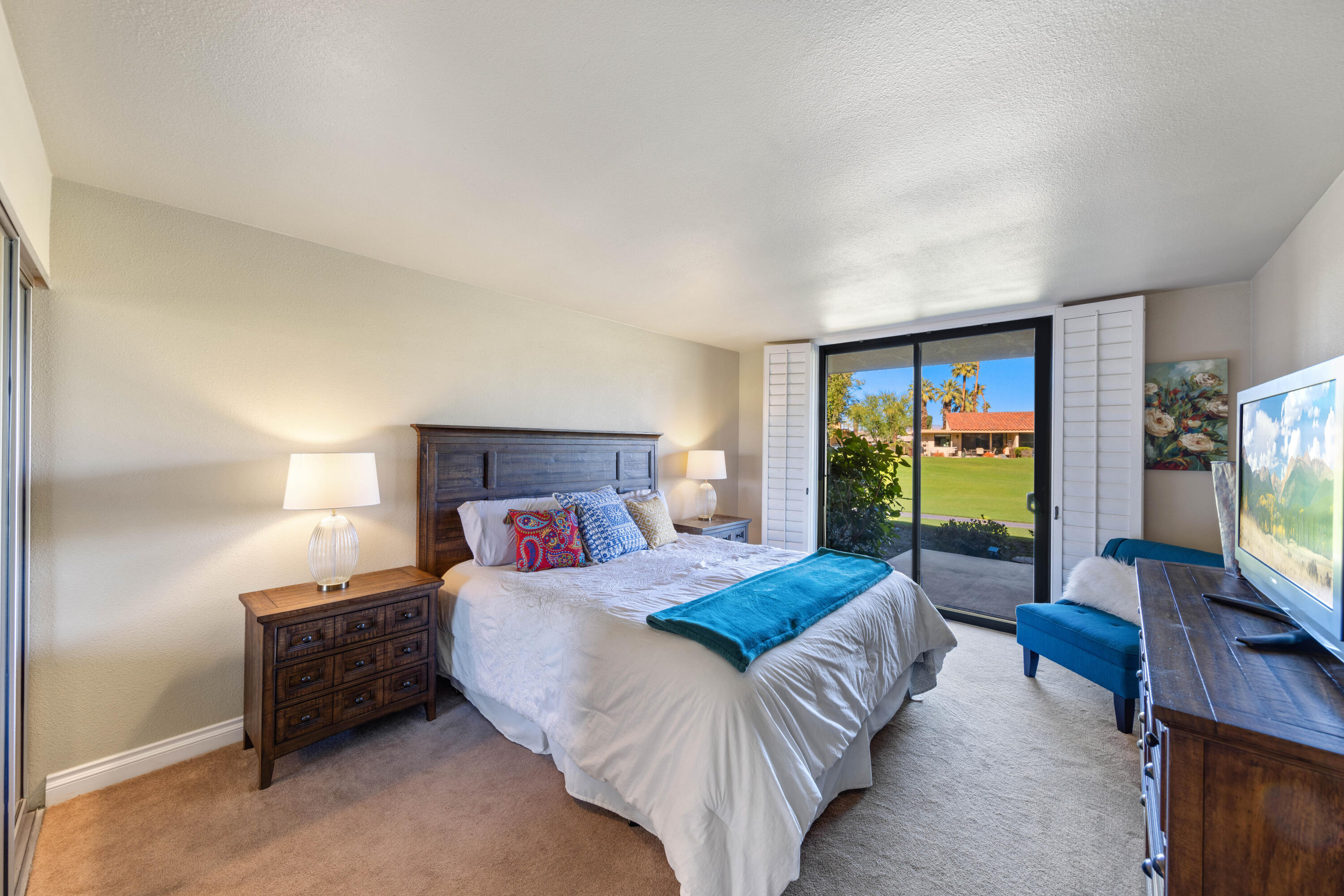 10 La Cerra Circle Rancho Mirage, CA 92270 - Photo 12 of 30 a bedroom with a bed and a flat tv screen on dresser