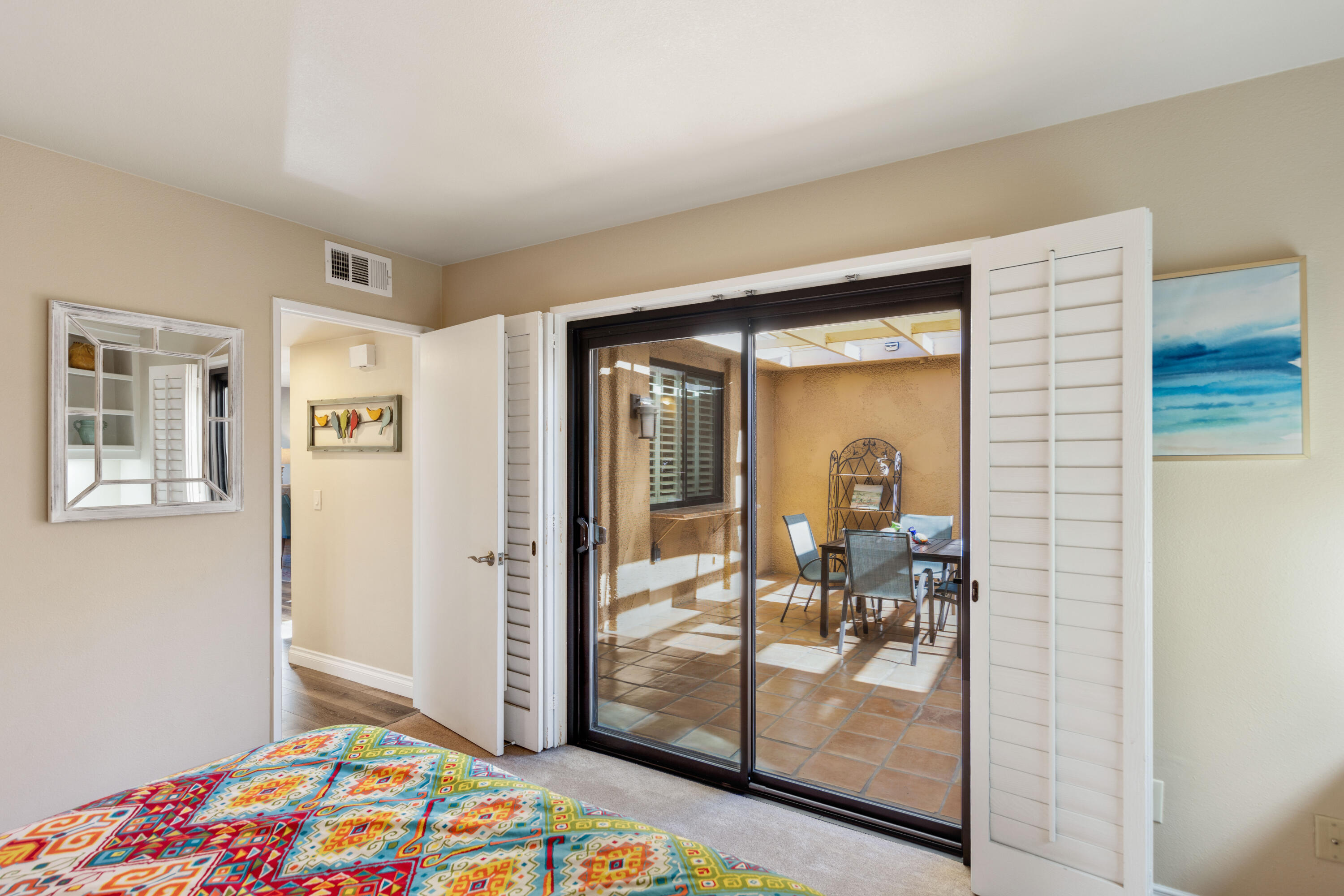 10 La Cerra Circle Rancho Mirage, CA 92270 - Photo 18 of 30 a bedroom with a bed and glass door