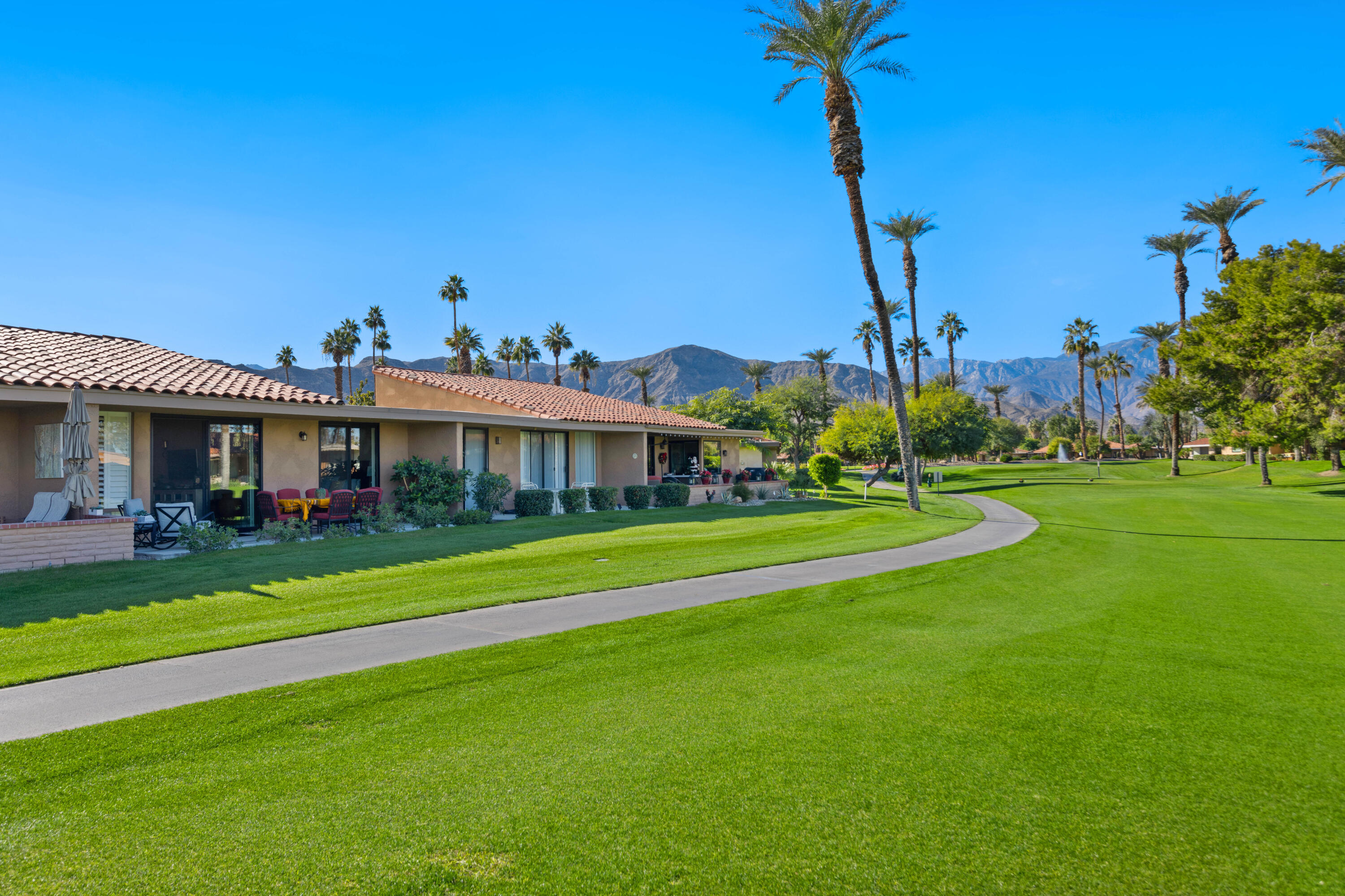 10 La Cerra Circle Rancho Mirage, CA 92270 - Photo 23 of 30 a front view of a house with a yard table and chairs