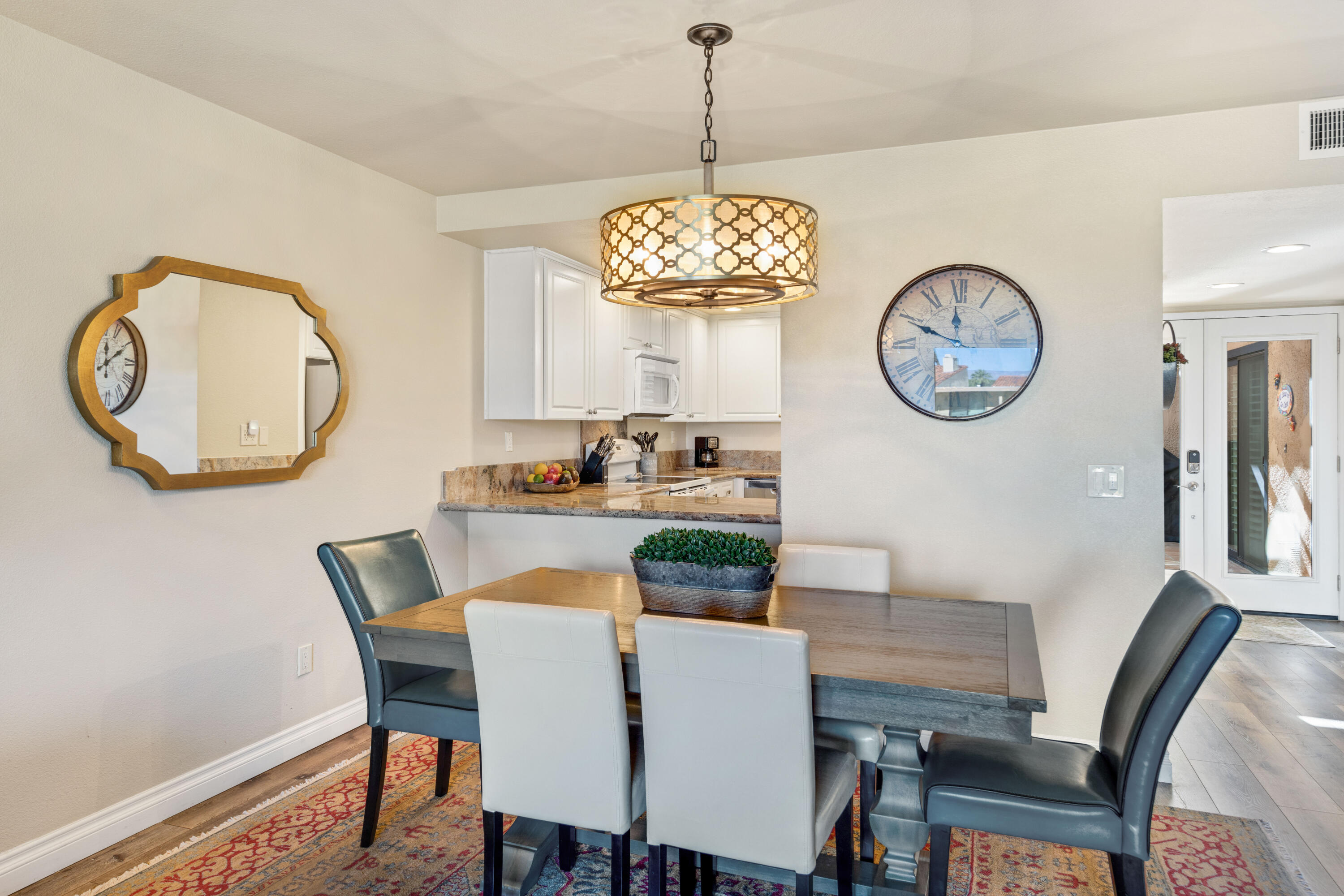 10 La Cerra Circle Rancho Mirage, CA 92270 - Photo 9 of 30 a dining room with wooden floor a chandelier and a window