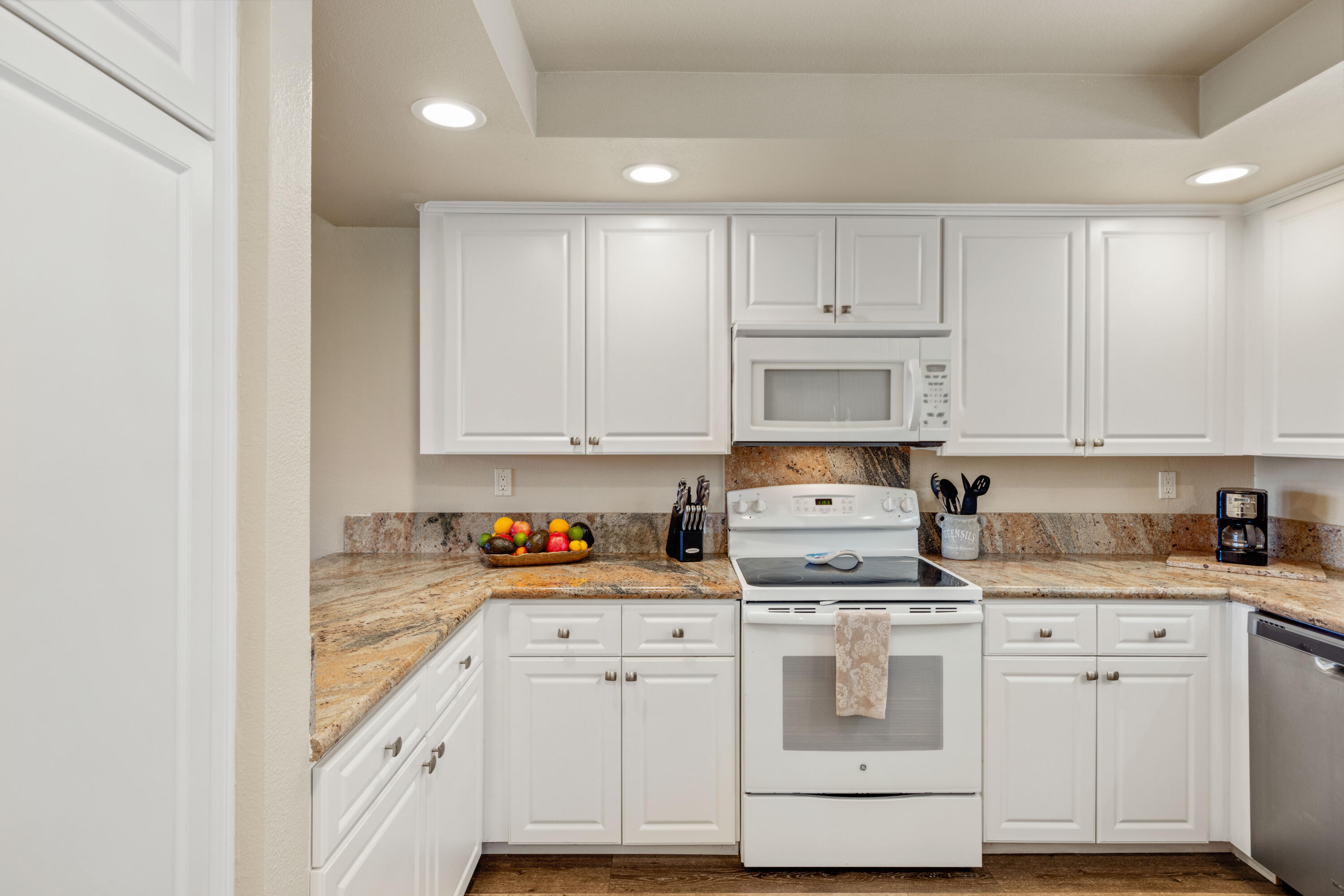 10 La Cerra Circle Rancho Mirage, CA 92270 - Photo 10 of 30 a kitchen with granite countertop white cabinets and white appliances