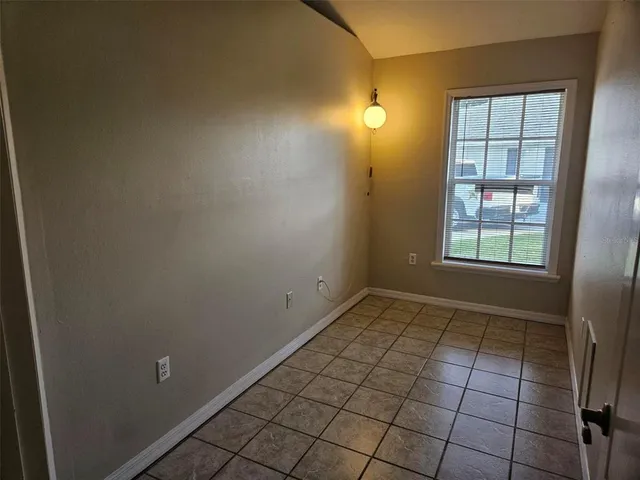 a view of an empty room with stairs and a window