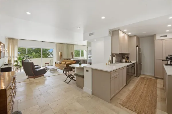 a large white kitchen with a large window and furniture