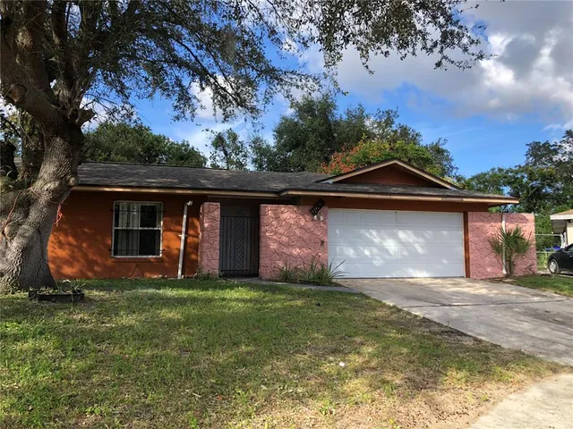 a front view of house with yard and trees in the background