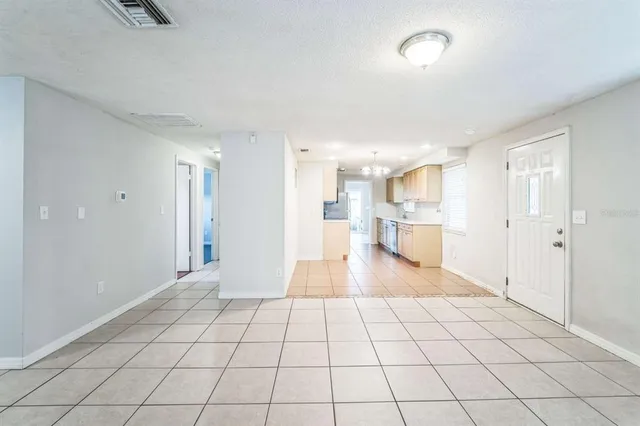 a view of an empty room and kitchen view