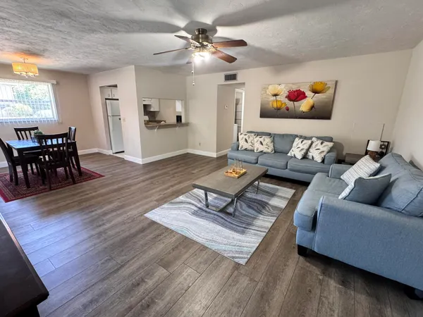 a living room with furniture and wooden floor