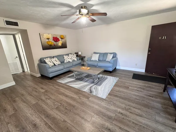 a living room with furniture rug and wooden floor
