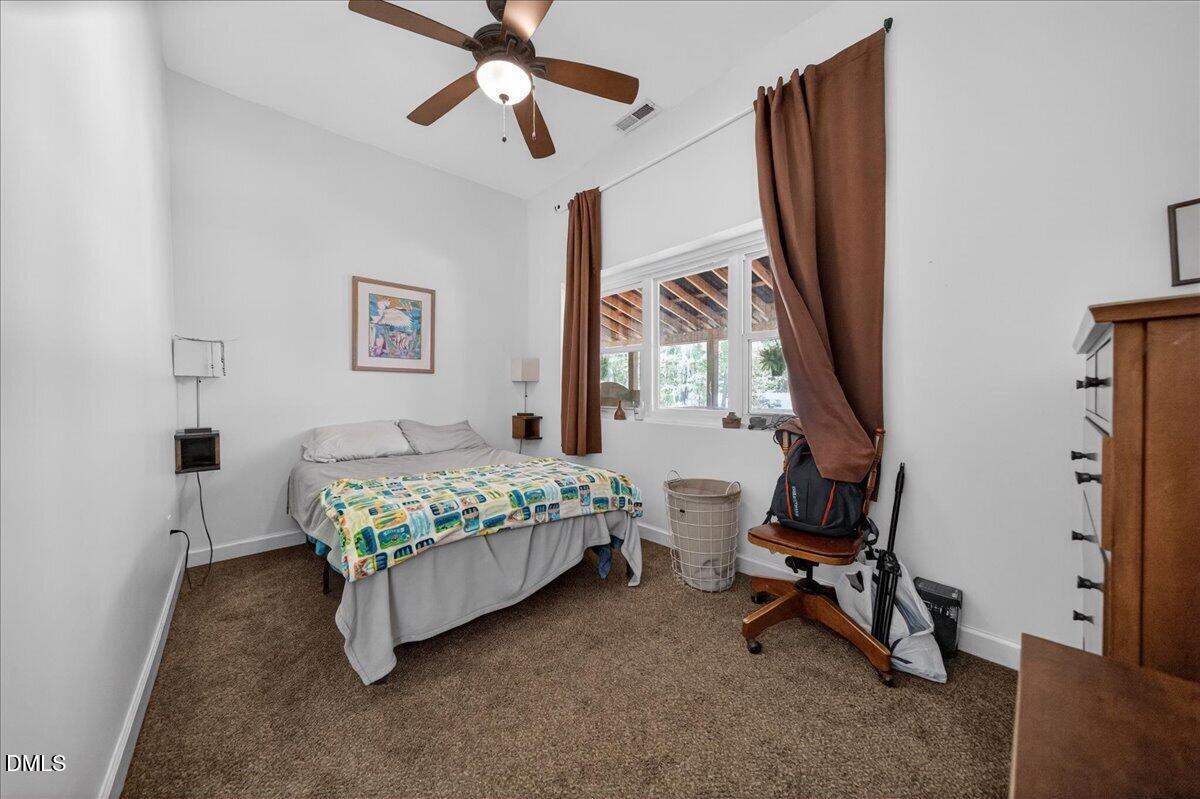 7303 Stony Hill Road Wake Forest, NC 27587 - Photo 21 of 31 a bedroom with a bed a chair and a chandelier