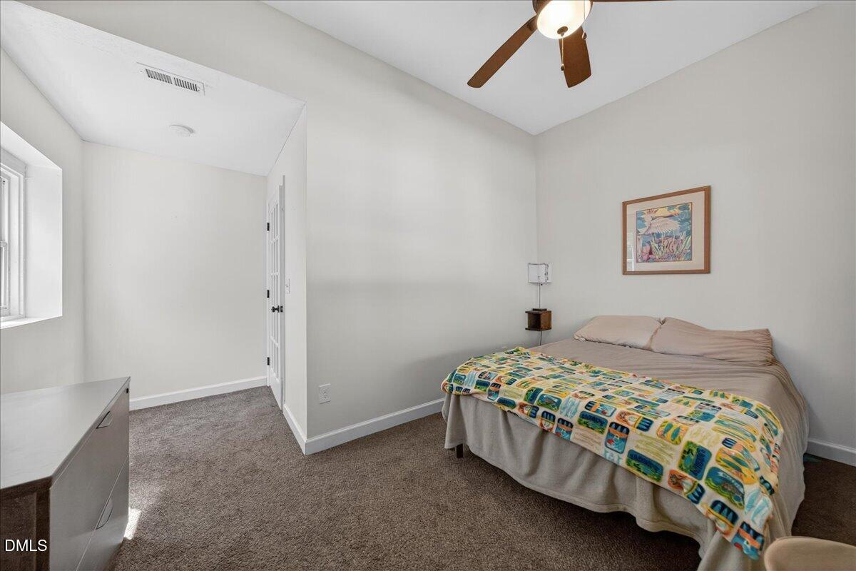 7303 Stony Hill Road Wake Forest, NC 27587 - Photo 22 of 31 a bedroom with a bed and a chandelier