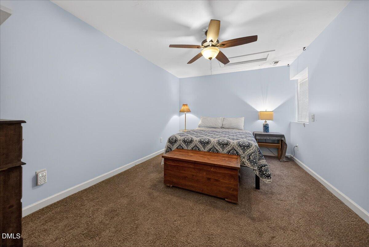 7303 Stony Hill Road Wake Forest, NC 27587 - Photo 23 of 31 a bedroom with a bed and a chandelier fan