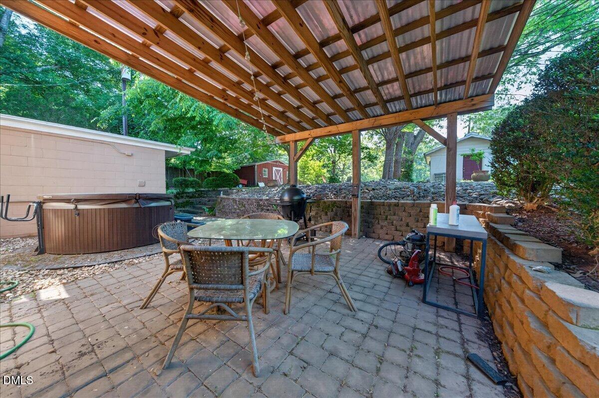 7303 Stony Hill Road Wake Forest, NC 27587 - Photo 28 of 31 a view of a patio with a table and chairs under an umbrella with a barbeque