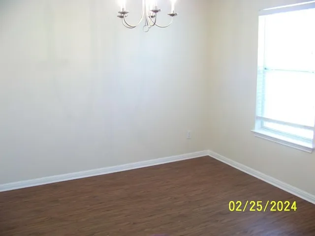 a view of hallway with livingroom and wooden floor