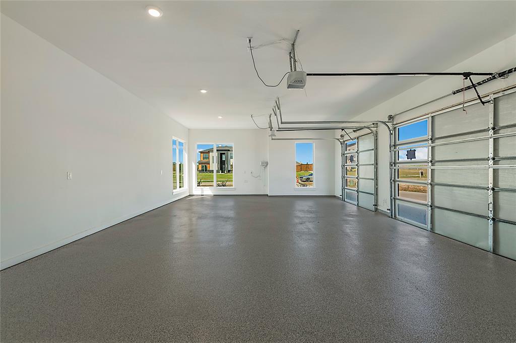 430 Whispering Way Red Oak, TX 75154 - Photo 22 of 40 Spacious multi-car garage featuring an epoxy-coated concrete floor, two glass-paneled garage doors with automatic openers, and recessed ceiling lighting