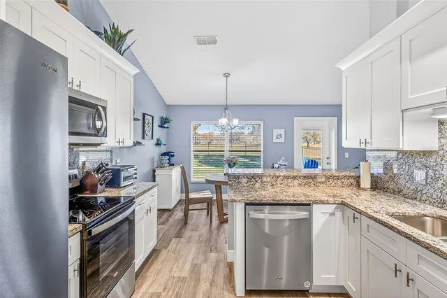 a kitchen with stainless steel appliances granite countertop a stove and cabinets