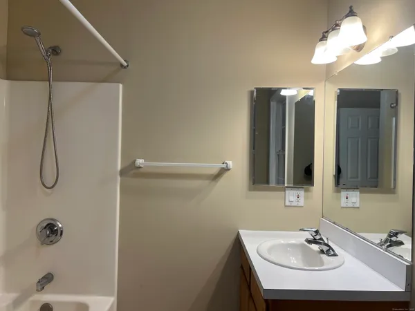a bathroom with a sink a light fixture and a mirror