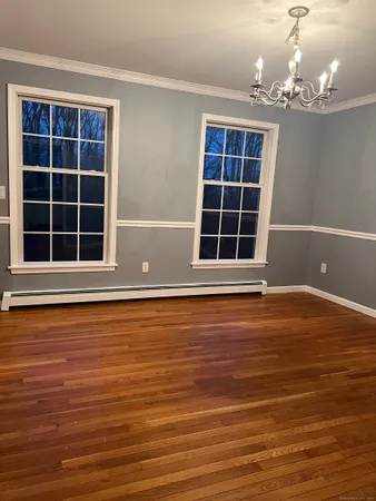 a view of empty room with windows and wooden floor