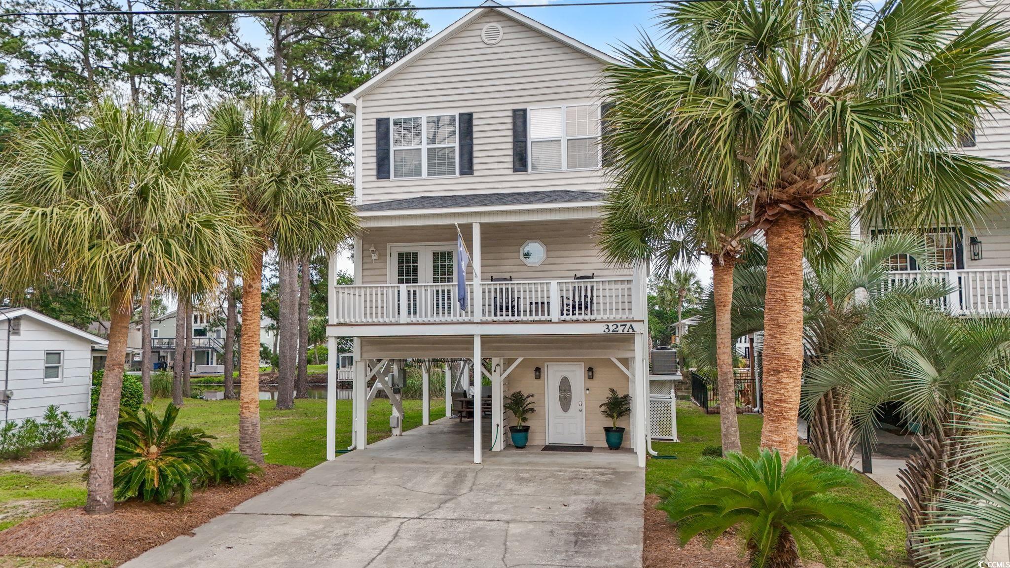 327 A Lakeside Drive Surfside Beach, SC 29575 - Photo 1 of 40 Beach home featuring a carport, concrete driveway, a porch, a front yard, and stairway