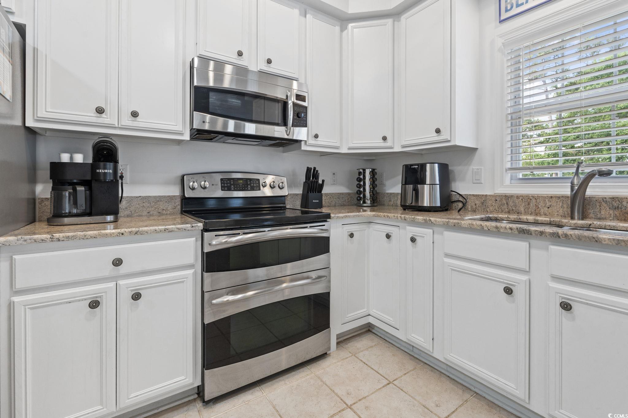 327 A Lakeside Drive Surfside Beach, SC 29575 - Photo 11 of 40 Kitchen with appliances with stainless steel finishes, white cabinets, a sink, and light tile patterned flooring