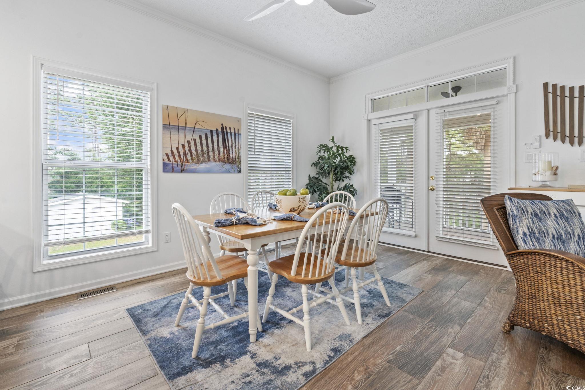 327 A Lakeside Drive Surfside Beach, SC 29575 - Photo 15 of 40 Dining space featuring ornamental molding, healthy amount of natural light, ceiling fan, wood finished floors, and a textured ceiling