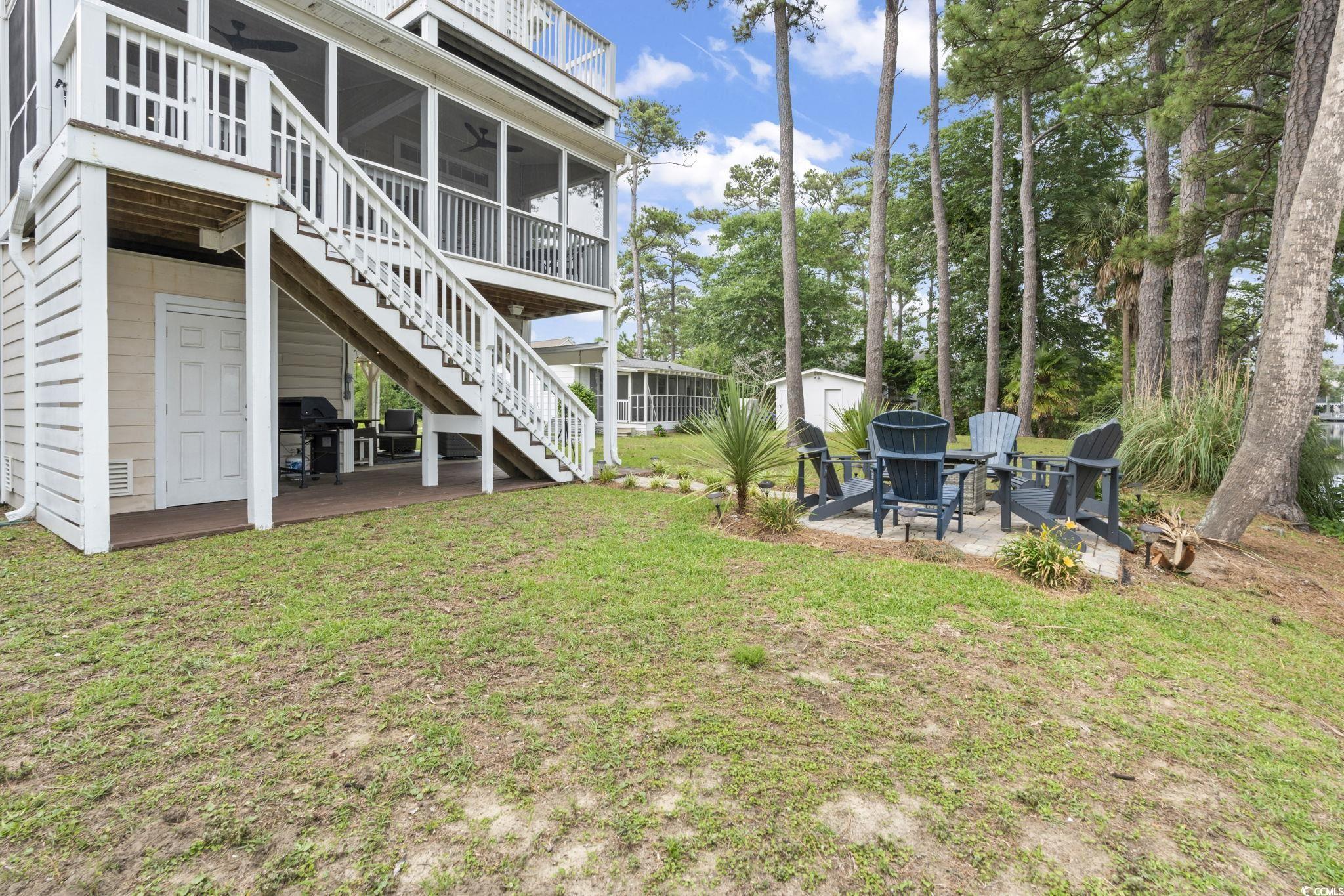 327 A Lakeside Drive Surfside Beach, SC 29575 - Photo 35 of 40 View of grassy yard featuring a sunroom, a patio area, stairway, and ceiling fan