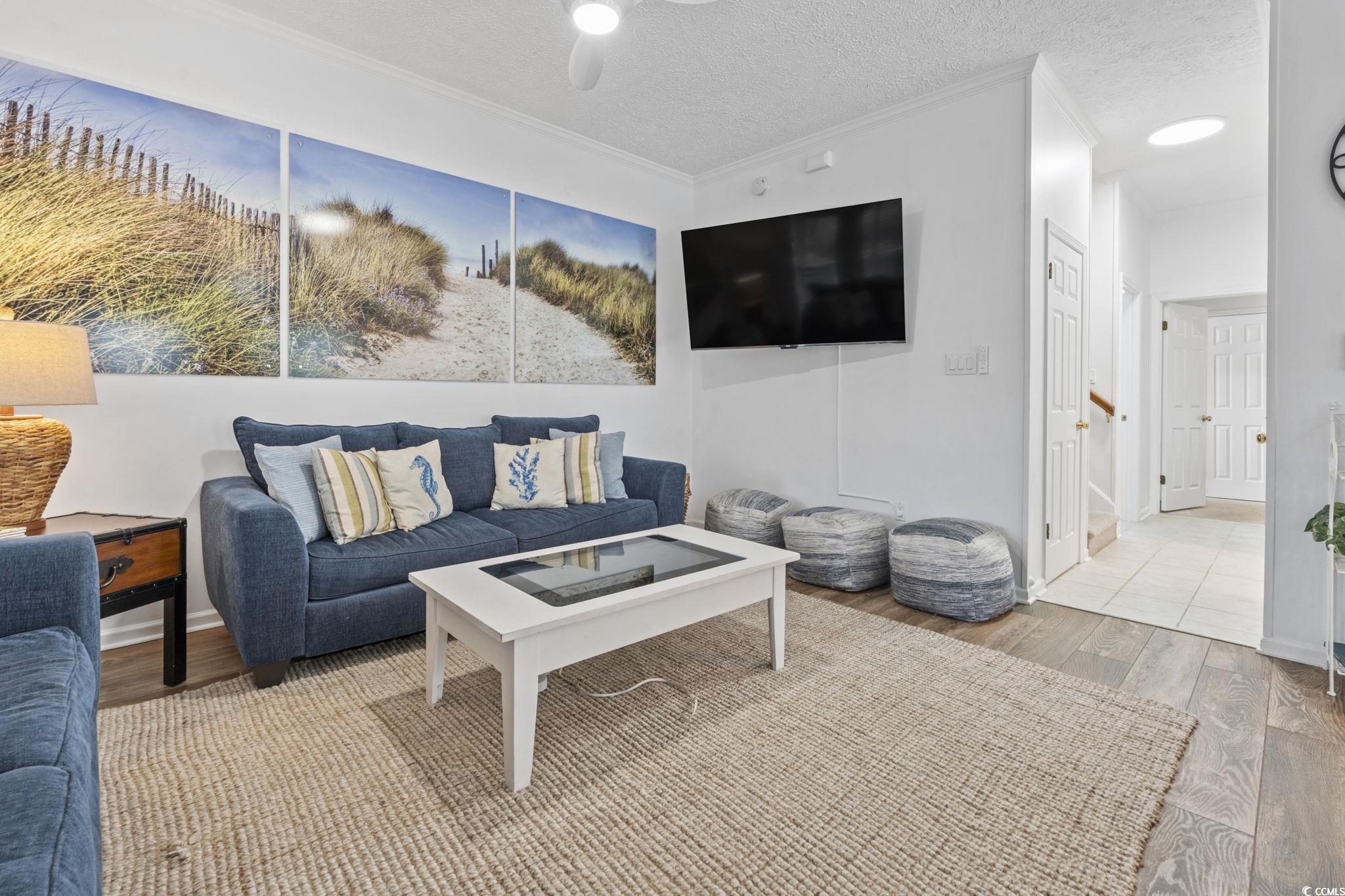 327 A Lakeside Drive Surfside Beach, SC 29575 - Photo 8 of 40 Living area featuring wood finished floors, crown molding, ceiling fan, and a textured ceiling