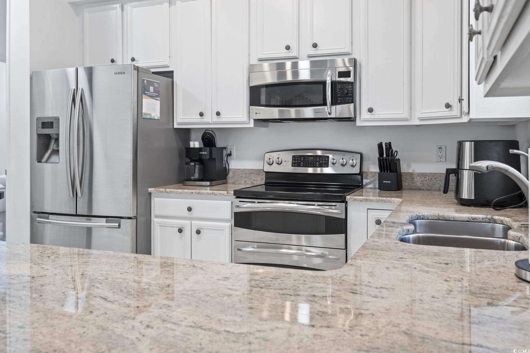 327 A Lakeside Drive Surfside Beach, SC 29575 - Photo 10 of 40 Kitchen featuring stainless steel appliances, white cabinetry, a sink, and light stone countertops
