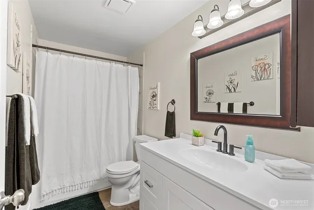 a bathroom with a sink vanity mirror and toilet