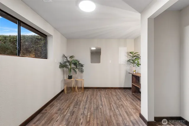 a view of a hallway with wooden floor and a potted plant
