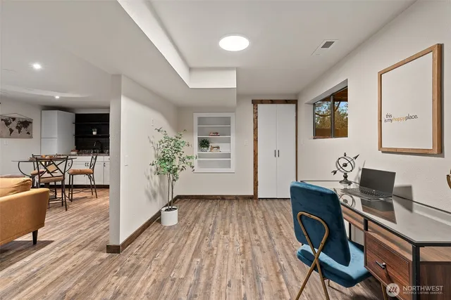a view of a workspace with furniture and wooden floor