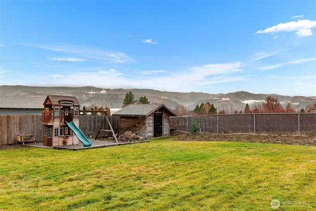 a view of a swimming pool with a yard and palm trees