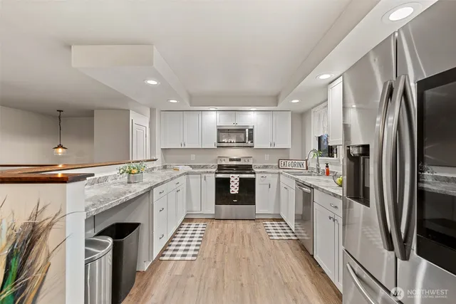 a kitchen with stainless steel appliances a refrigerator sink and cabinets