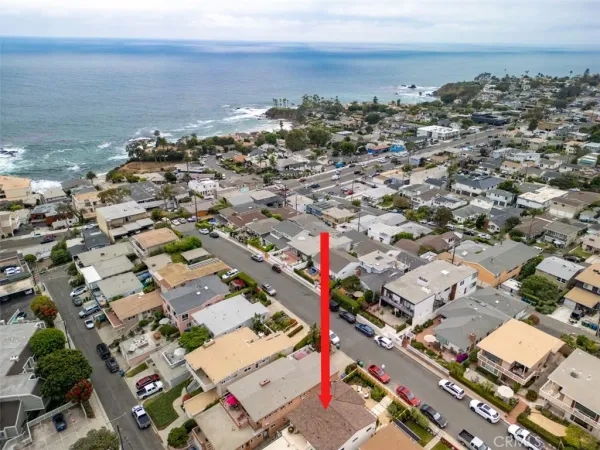 an aerial view of a city with ocean view in back