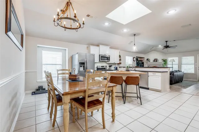 a kitchen with a dining table chairs and cabinets