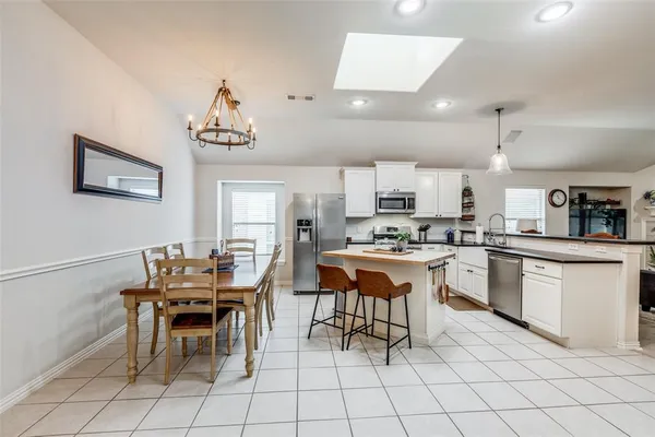 a kitchen with a dining table chairs and white cabinets