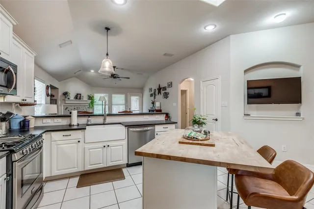 a kitchen with stainless steel appliances kitchen island granite countertop a sink and cabinets