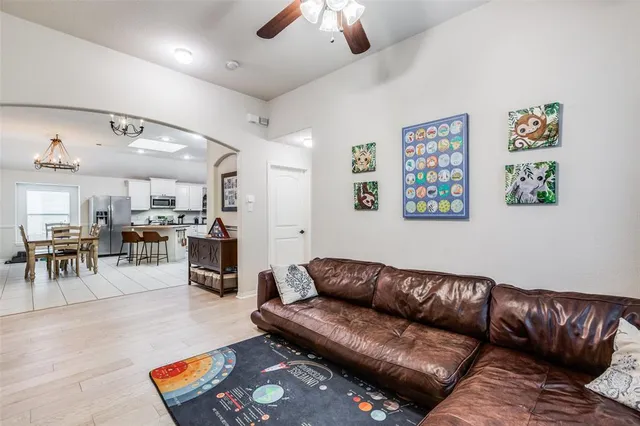 a living room with furniture kitchen view and a chandelier