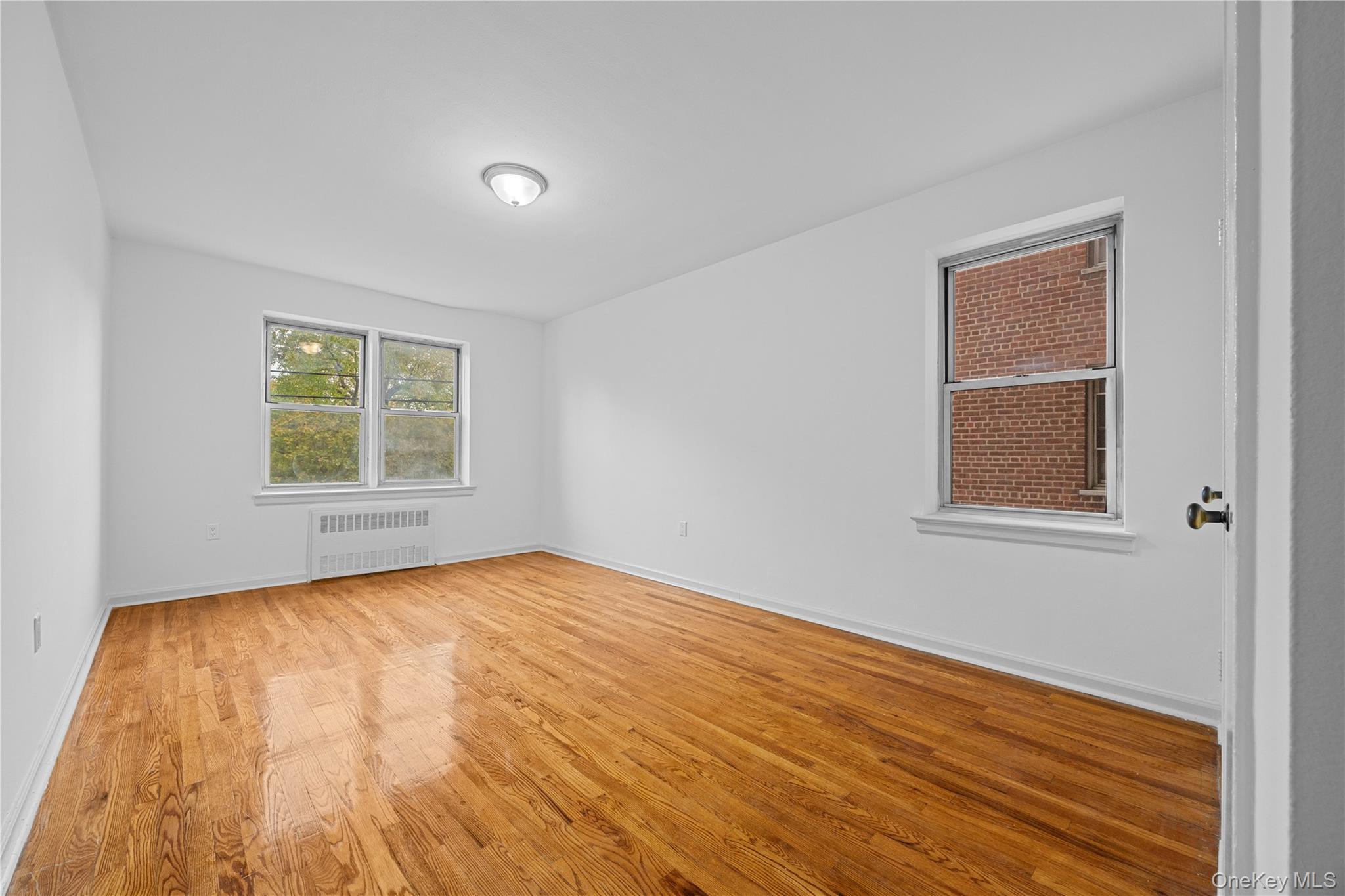 255 Bronx River Road, Unit 4M Yonkers, NY 10704 - Photo 14 of 19 a view of an empty room with wooden floor and a window