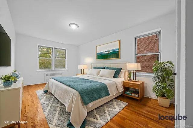 a bedroom with a bed windows and a flat screen tv