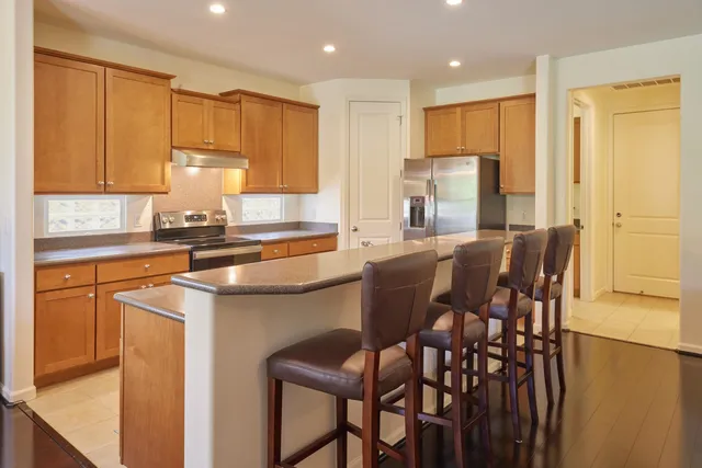 a kitchen with stainless steel appliances granite countertop a sink refrigerator and cabinets