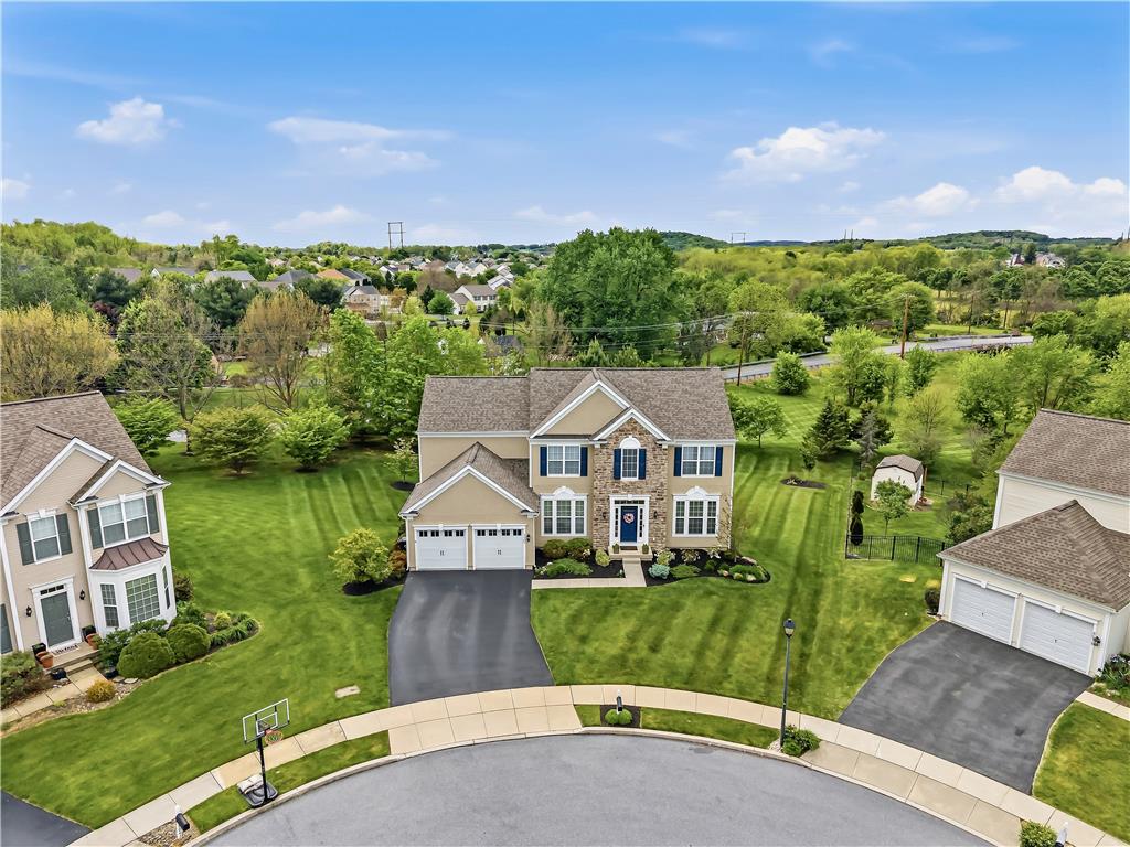 9031 Pathfinder Road Breinigsville, PA 18031 - Photo 2 of 63 A commanding two-story residence with attached garages and a perfectly manicured lawn, nestled in a vibrant neighborhood.