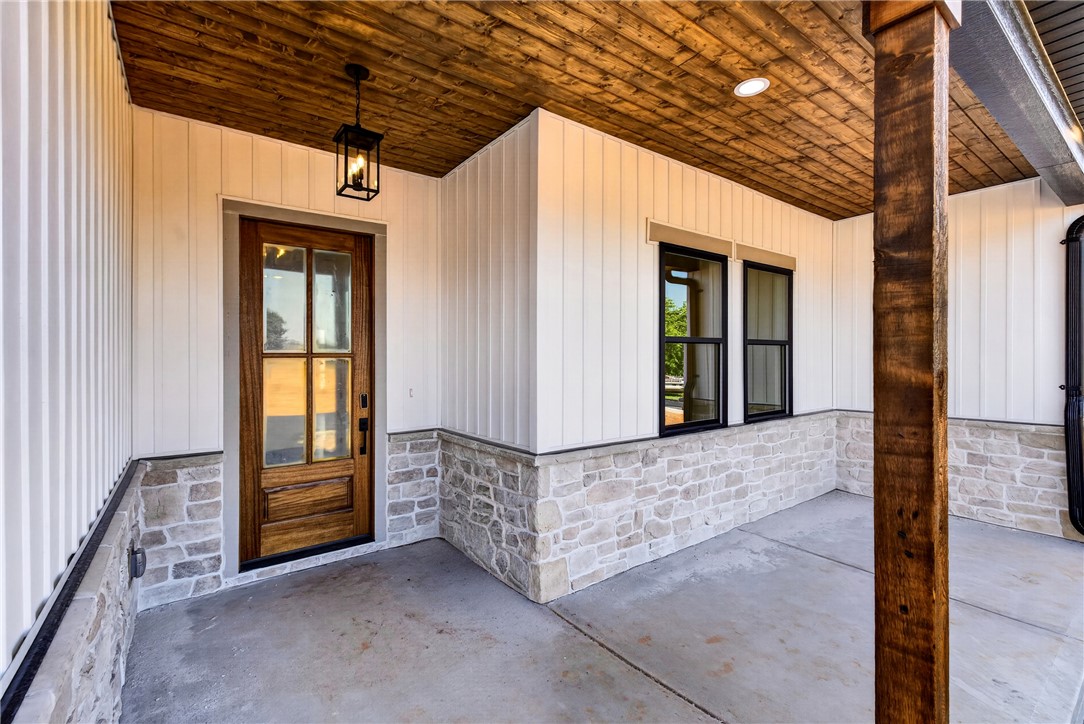 416 Blume Road Anderson, SC 29625 - Photo 4 of 29 A welcoming front porch features a natural wood door, board and batten siding, and stone accents, creating inviting curb appeal.