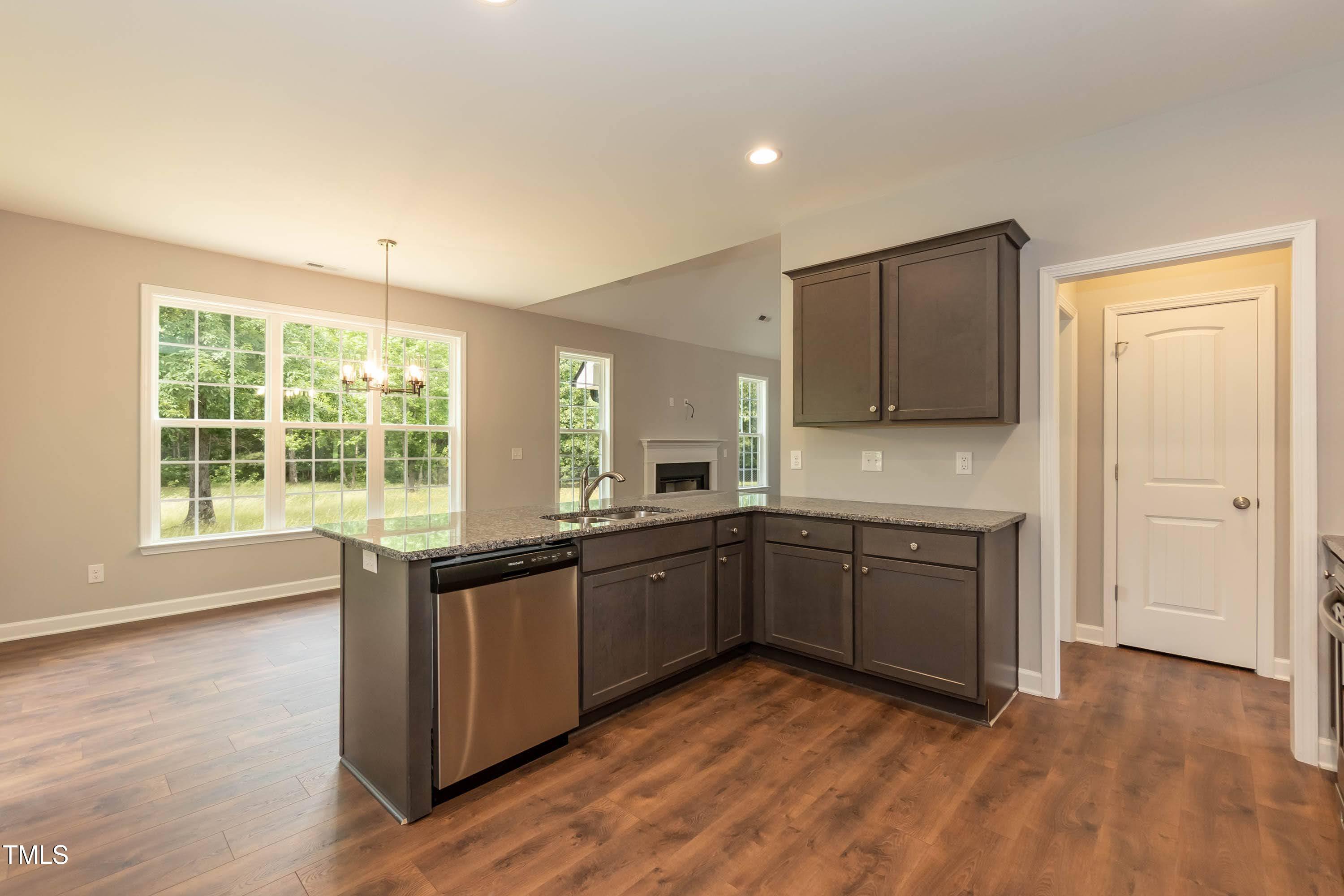748 Rivers Edge Parkway Roanoke Rapids, NC 27870 - Photo 6 of 42 a large kitchen with kitchen island granite countertop wooden floors and white stainless steel appliances