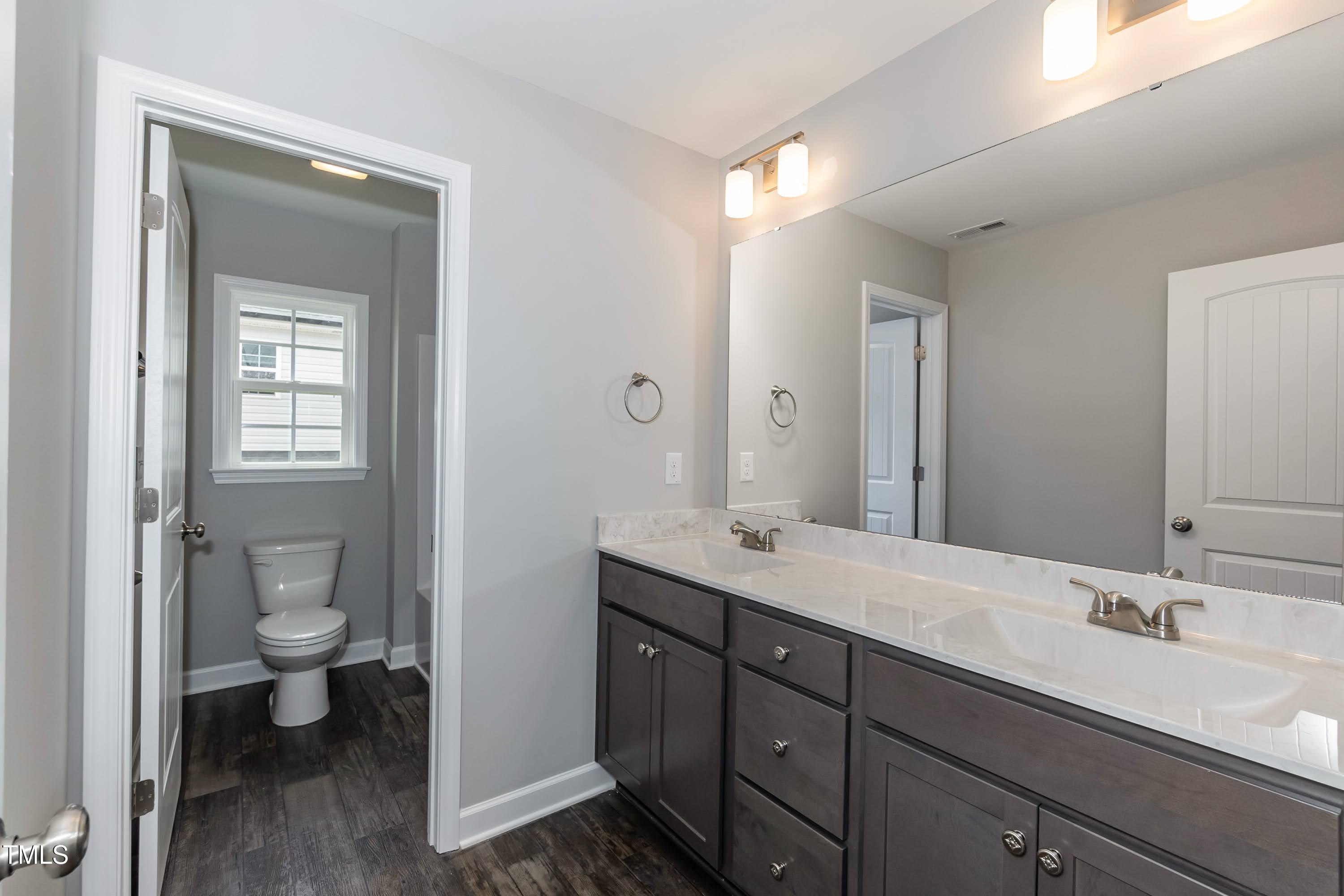 748 Rivers Edge Parkway Roanoke Rapids, NC 27870 - Photo 17 of 42 a bathroom with a granite countertop sink a toilet and a large mirror