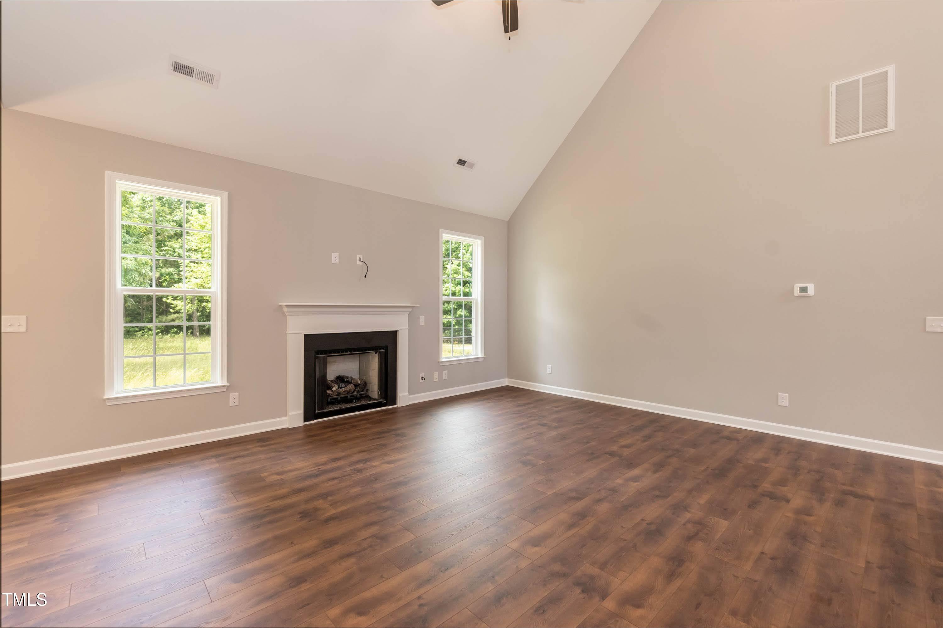 748 Rivers Edge Parkway Roanoke Rapids, NC 27870 - Photo 3 of 42 an empty room with wooden floor a fireplace and windows
